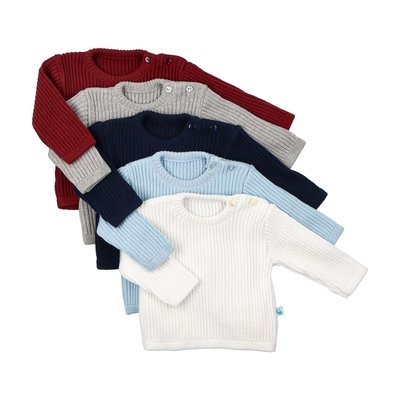 Sobre fundo cinzento, as quatro variações de cor da camisola de bebé e criança, em malha tricotada 100% algodão. Branco cru em primeiro plano, depois azul claro, depois azul marinho, cinza mescla e, por fim, bordeaux. As camisolas estão dobradas, com a manga direita dobrada sobre a frente.