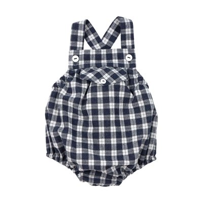 Fofo de alças para bebé em vaiela muito macia e ligeiramente cardada, ao xadrez azul e branco cru, com forro interior em tecido branco. 100% algodão, com bolso na frente, as alças cruzam nas costas e apertam à frente com botões brancos. Elástico dos lados, nas costas e nas pernas. Molas no entrepernas. Vista de frente, fundo branco.