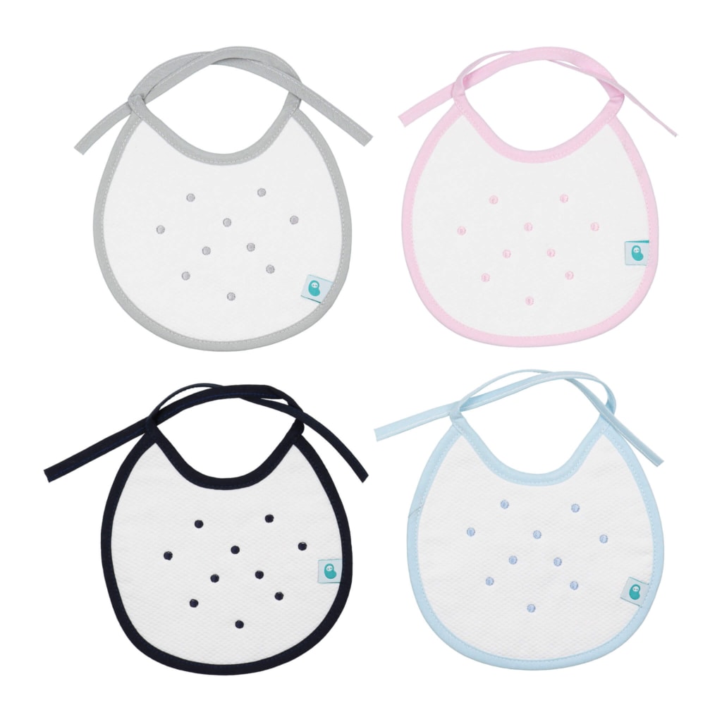 Conjunto de quatro babetes de bebé em tecido piquet com pintas. Disponível em azul claro, azul marinho, cinzento e rosa.