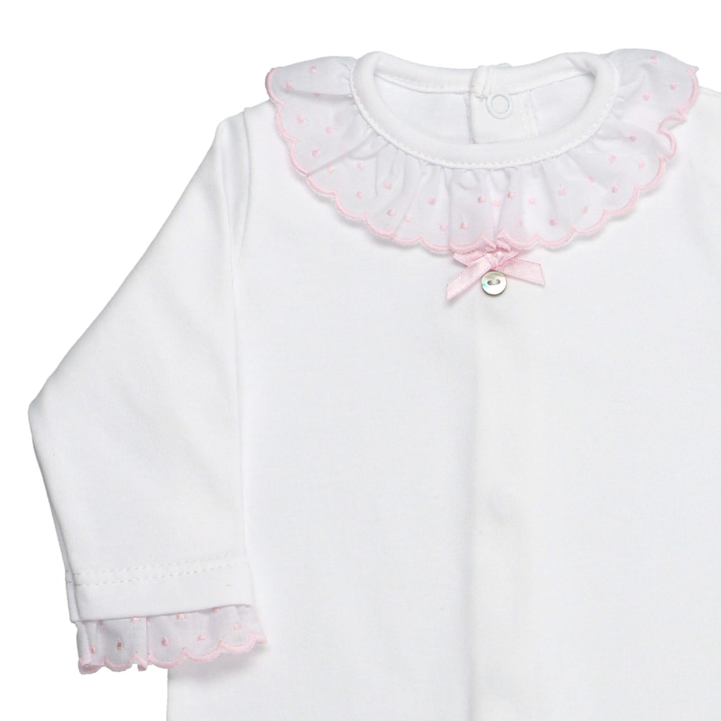 Pormenor da gola e punhos de babygrow de bebé em tecido de algodão branco com a gola e punhos rosa.