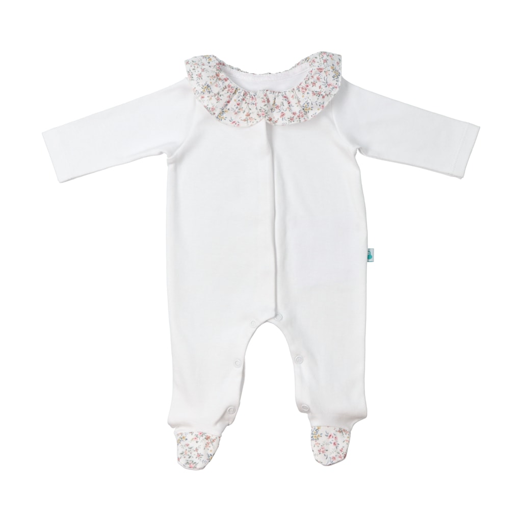 Babygrow para bebé feito em tecido de algodão branco tipo jersey. Tem a gola e os pés em tecido com um padrão de flores.