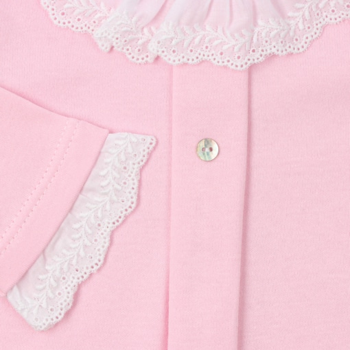 Manga em tecido branco com renda de um babygrow de bebé feito em algodão de cor rosa liso.