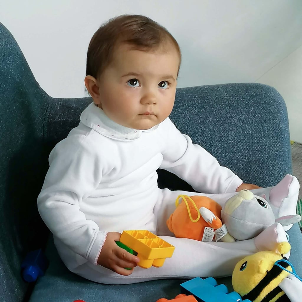 Bebé vertido com babygrow branco com a gola em tecido Piquet