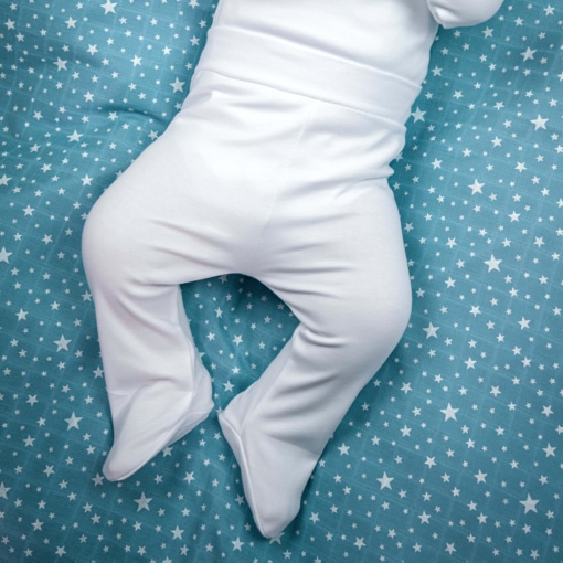 Bebé deitado vestido com calças interiores brancas.