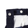 Pormenor do forro interior branco e do elástico interior para ajuste da cintura de uns calções para bebé feitos em tecido de bombazine azul 100% algodão.
