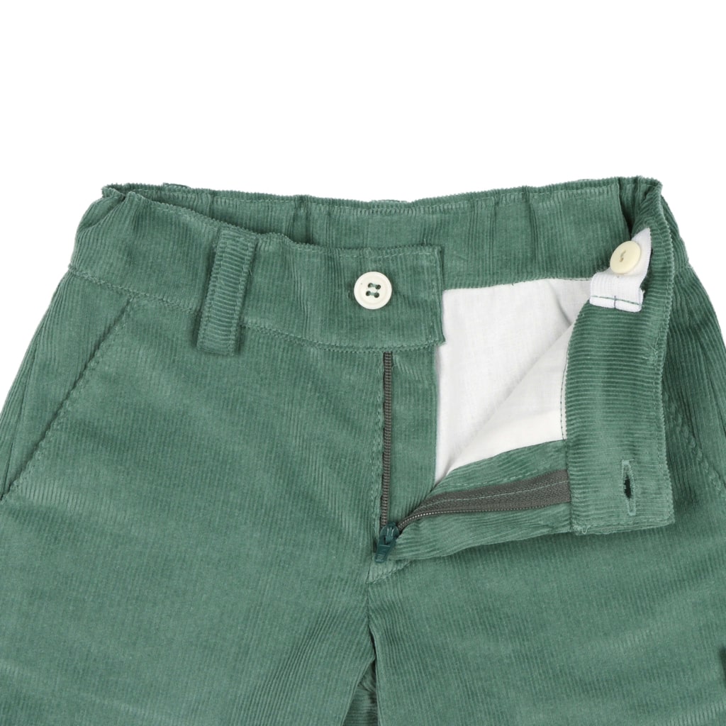 Pormenor do forro interior branco e do elástico interior para ajuste da cintura de uns calções para bebé feitos em tecido de bombazine verde 100% algodão.