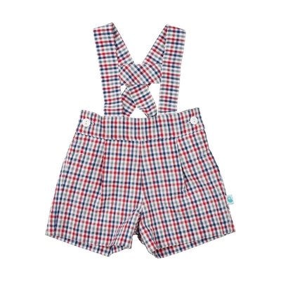 Calções de bebé tirolês com padrão quadriculado azul, cinzento, vermelho e branco. Destaques de texto salientam algumas características: 100% algodão; forro interior; alças à tirolesa à frente; botões dos lados e elástico atrás.