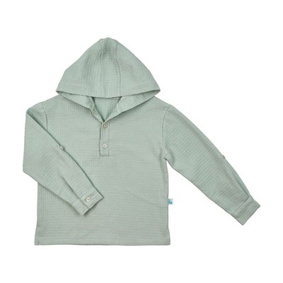 Camisa para criança tipo túnica com textura de xadrez em relevo na cor verde. Destaques de texto salientam algumas características: 100% algodão orgânico; tem carapuço; abertura com botões na frente; mangas compridas ajustáveis.
