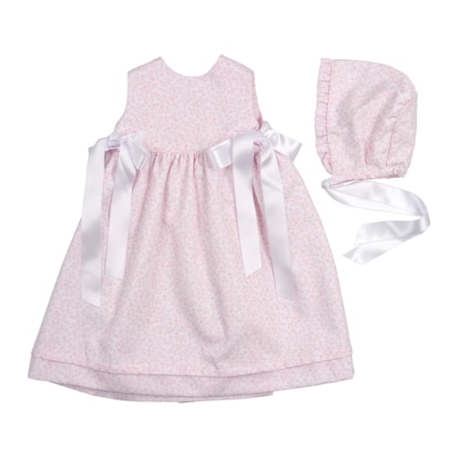 Conjunto de cueiro de bebé rosa e touca no mesmo tecido.