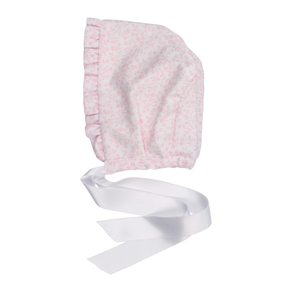 Touca para bebé em tecido de algodão rosa com padrão de flores brancas e fita em cetim branco.