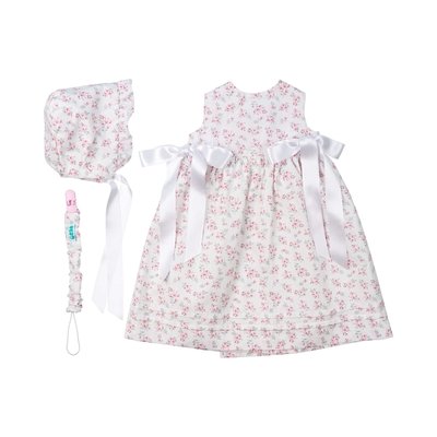 Conjunto de uma touca e um cueiro para bebé feitos em tecido de algodão com uma estampa de flores.