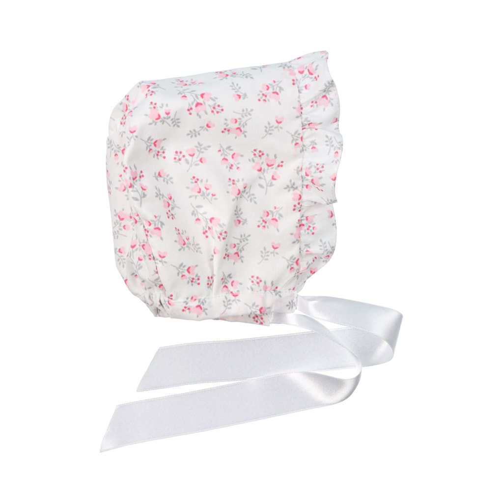 Touca de bebé em tecido branco com estampado de flores e folho. Aperta com fita de cetim branca.