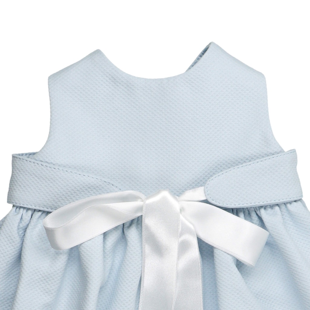 Cueiro para bebé em tecido de piquet azul com uma fita de cetim branca à frente que fecha em laço.