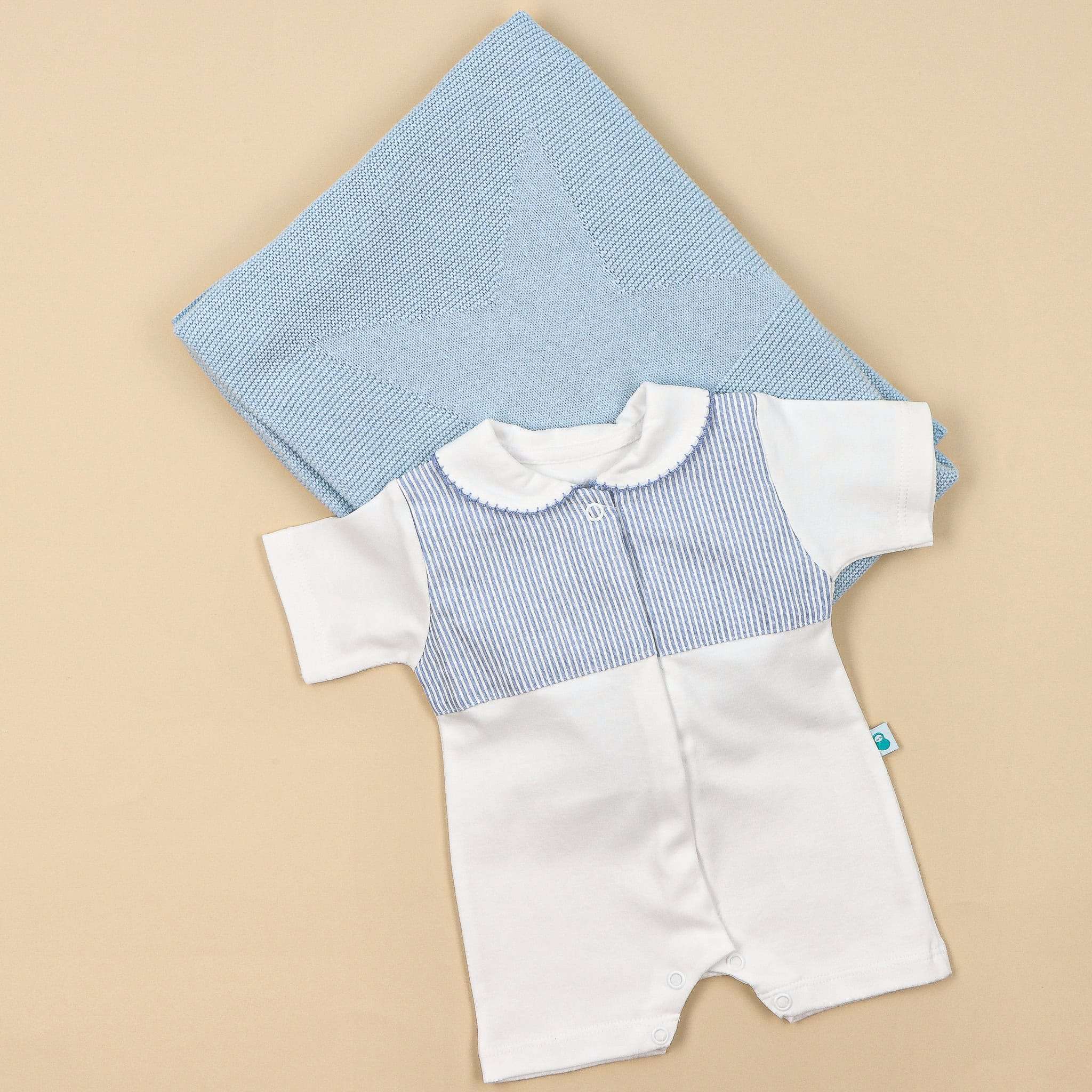 Manta e babygrow de bebé com a manga e a perna curta.