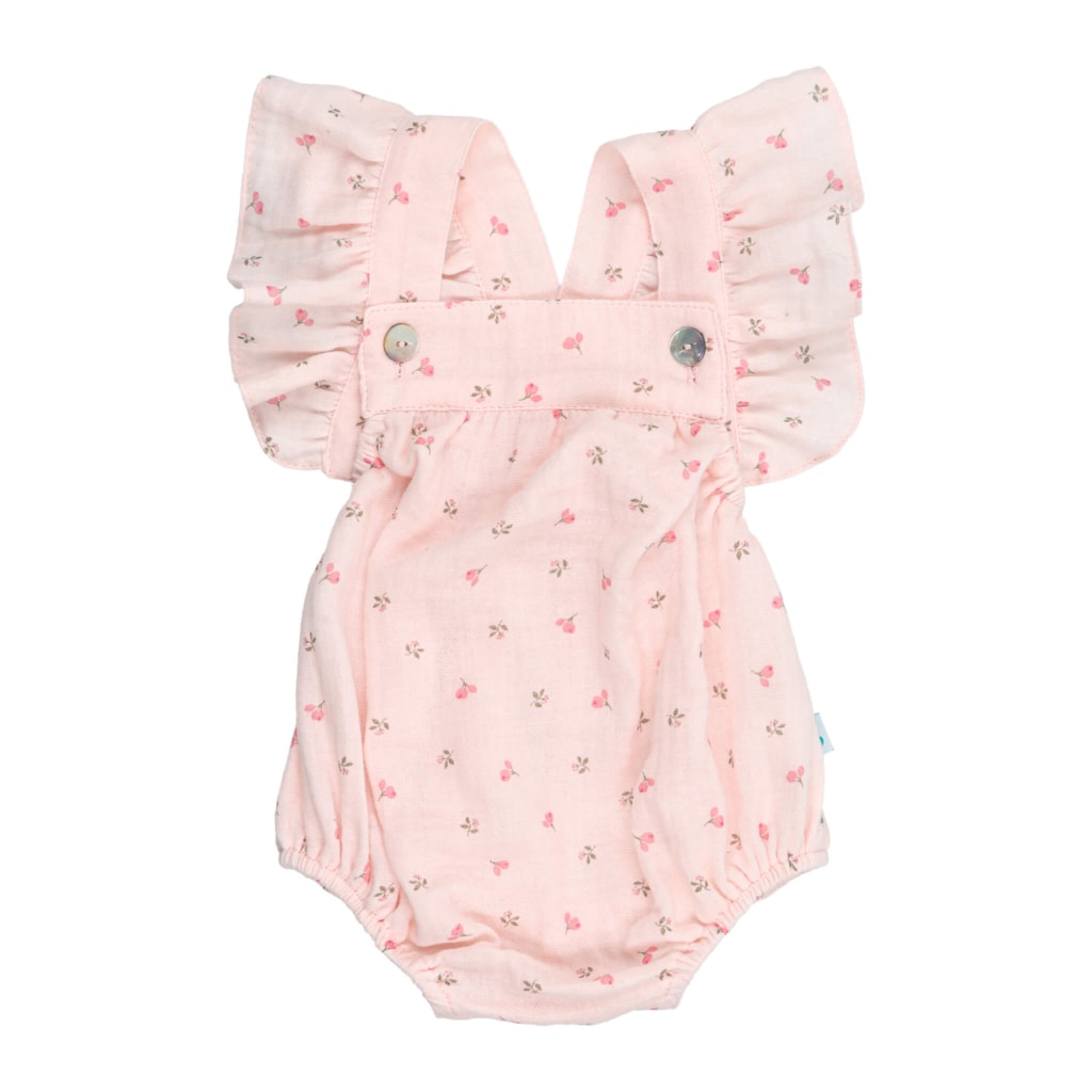 Fofo de bebé em tecido rosa com estampado em flores. Tem folhos nas alças e é feito em tecido 100% algodão orgânico.