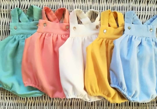 Conjunto de fofos e roupa para bebé em diferentes cores.