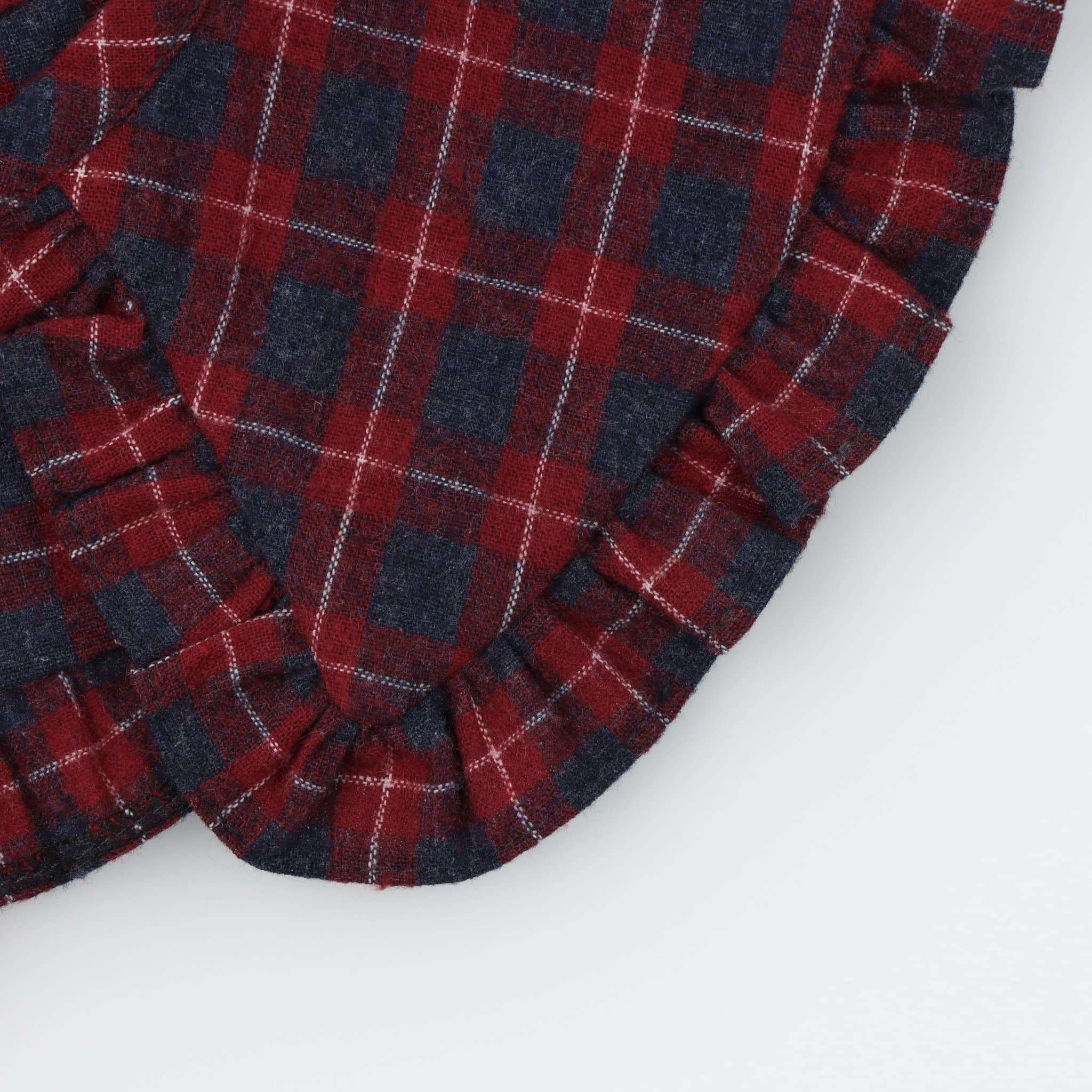 Detalhe da gola para menina amovível, com folhinho a toda a volta, feita em tecido vaiela com padrão xadrez em tons de azul acinzentado e bordeaux. Aperta na frente com um botão escondido.