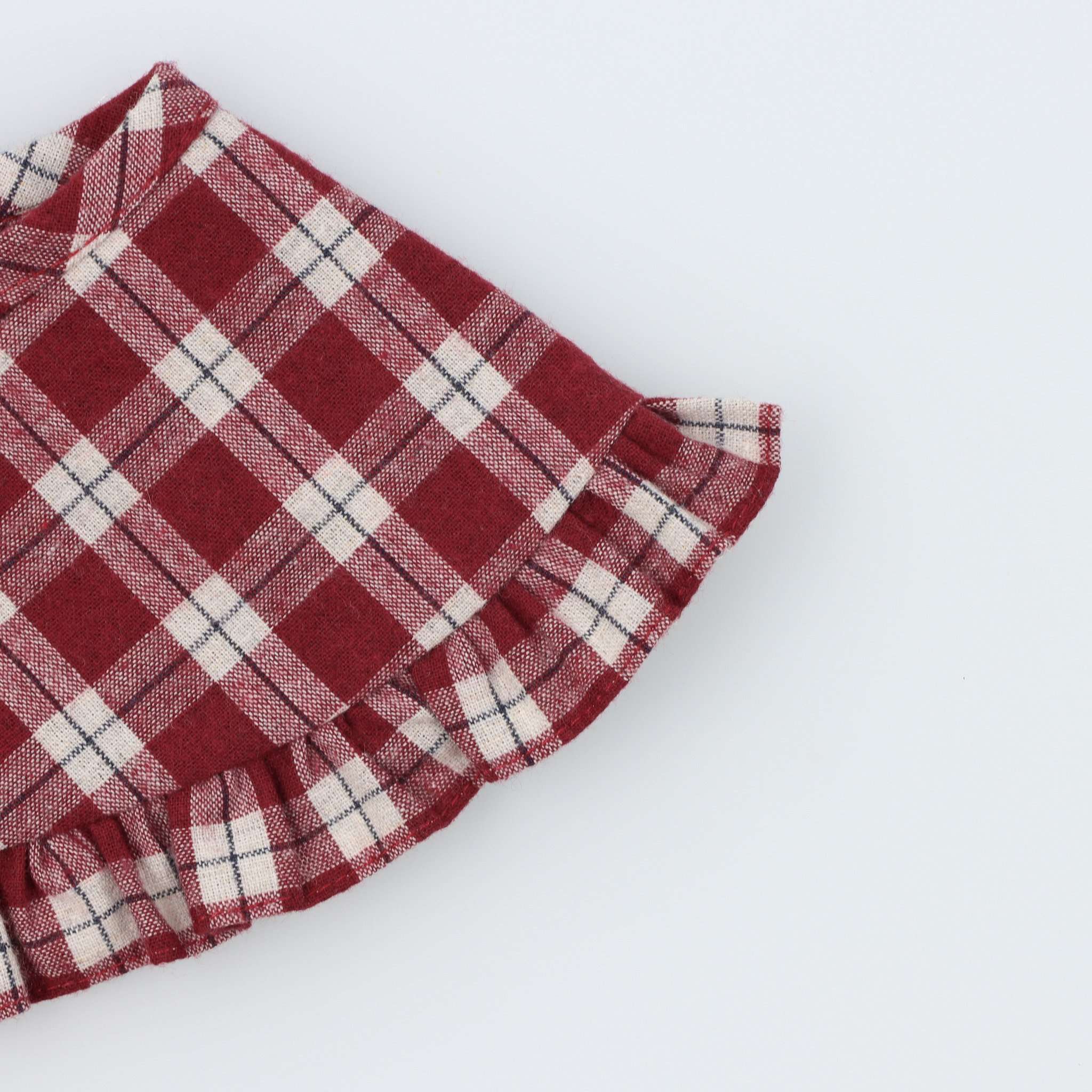 Gola de Menina Xadrez Bordeaux com folho a toda a volta. Aperta com botão na frente. É perfeita para looks matchy de meninas mais crescidas! Detalhe de folho visto de frente.