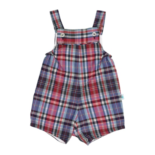 Jardineiras de bebé com perna curta feitas em tecido xadrez de algodão com tons de vermelho, azul e branco. Têm botões de madrepérola nas alças, forro interior branco e um elástico suave de lado para melhor ajuste.