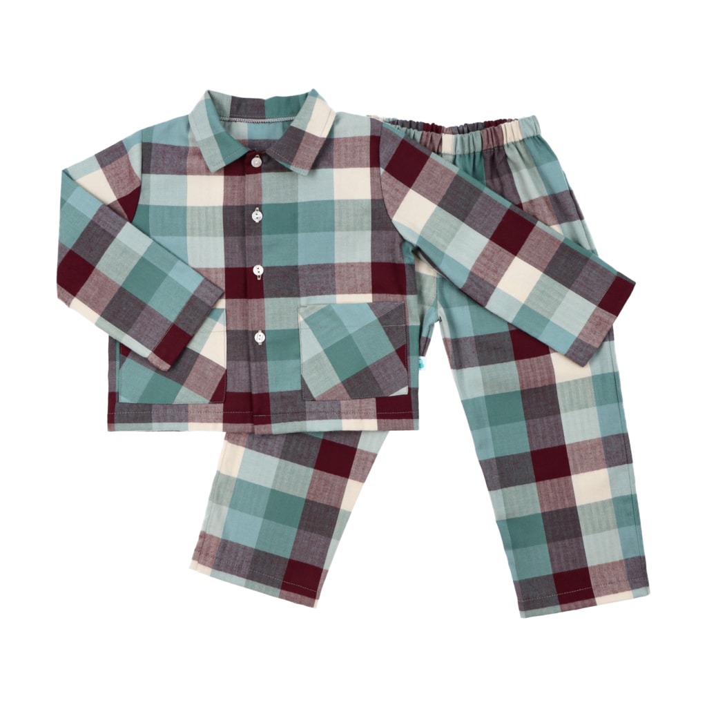 Vista de frente de pijama de flanela 100% algodão. Camisa com gola de lapela e bolsos na frente, sobreposta às calças. Braço esquerdo aberto e braço direito dobrado. Fundo branco.