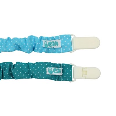 Dois prende chupetas feitos em tecido de muselina, um deles azul com pintas brancas e o outro verde com pintas brancas. Têm o fecho em plástico branco.