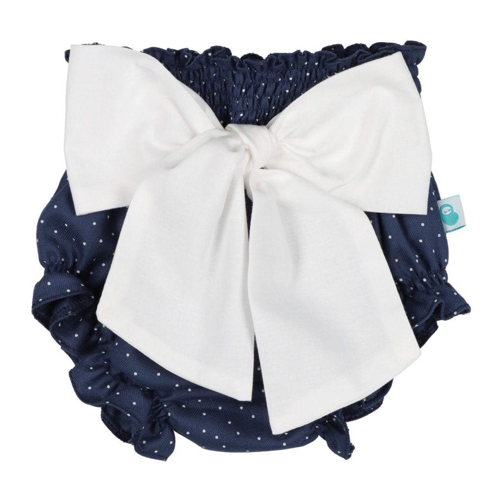 Tapa Fraldas para bebé em tecido de algodão azul marinho com pintas brancas e laço branco à frente. Elástico muito confortável na cintura e nas pernas.