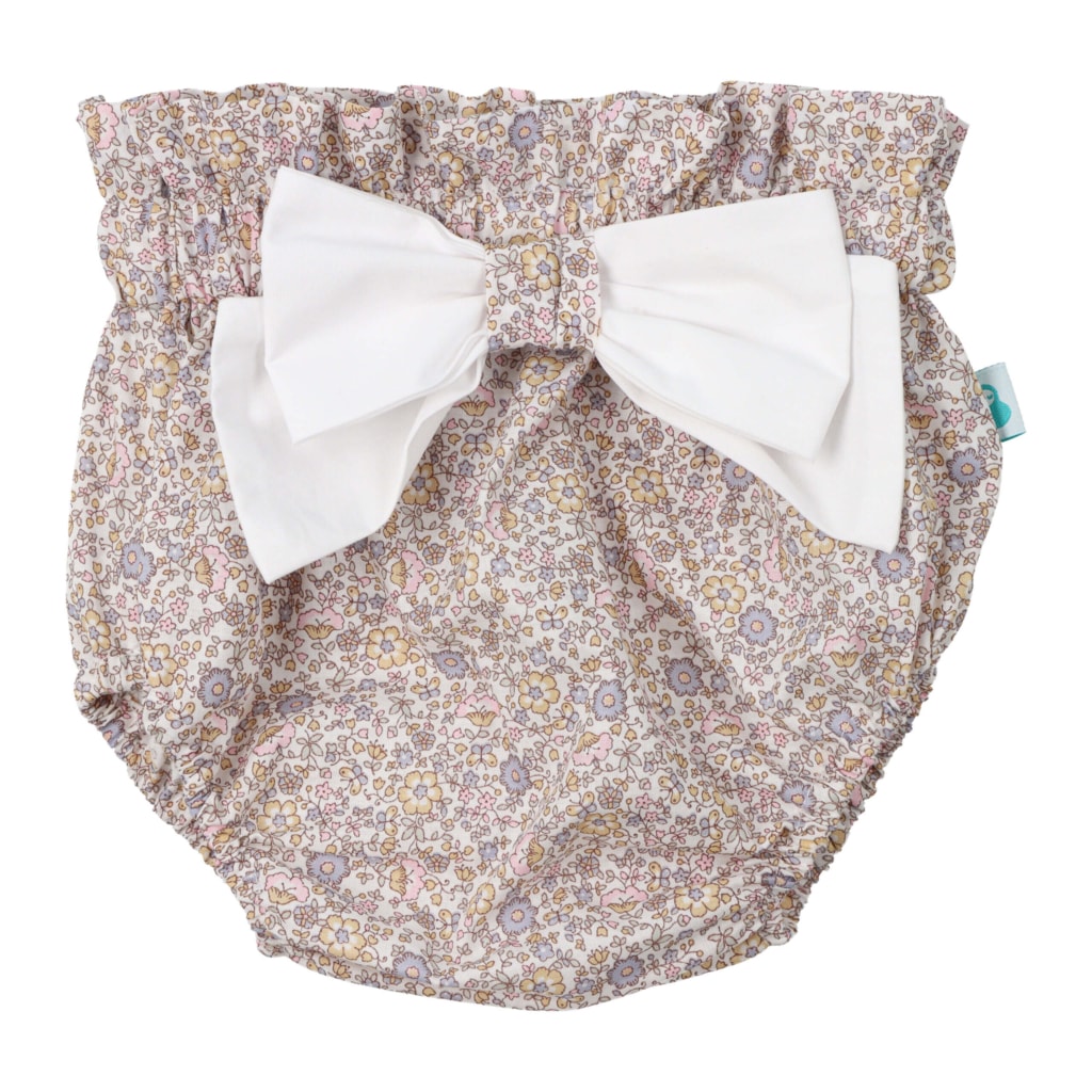 Tapa fraldas para bebé feito em tecido com padrão de flores 100% algodão. Tem um laço branco de tecido na frente.