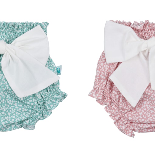 Conjunto de dois tapa fraldas de bebé verde e rosa com flores brancas e laço em tecido branco na frente.