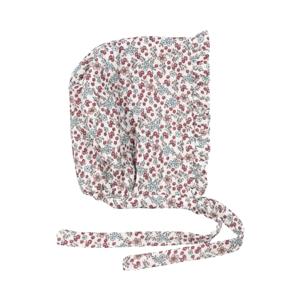 Touca de bebé em tecido branco com estampado de flores e folho. Aperta com fita.