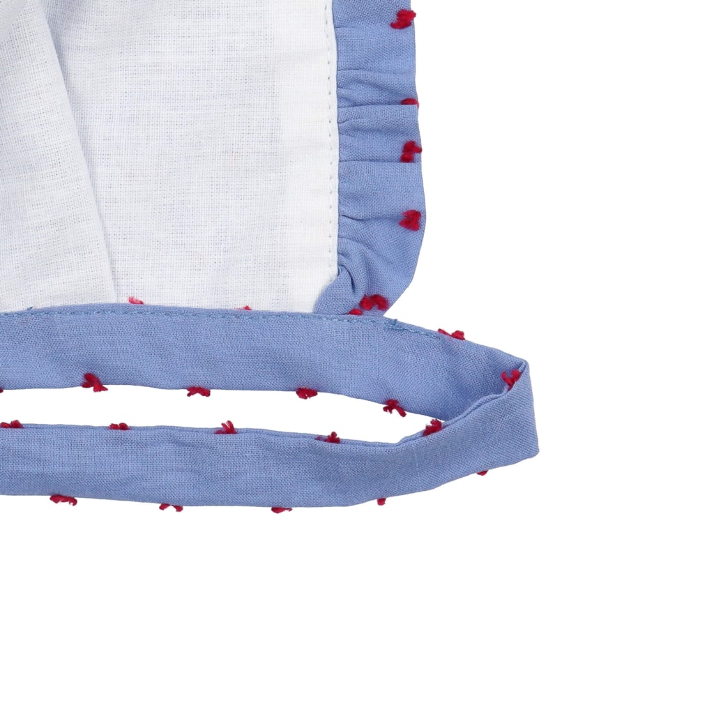 Forro interior branco de touca para bebé feita em tecido de algodão azul plumeti com pintas vermelhas.